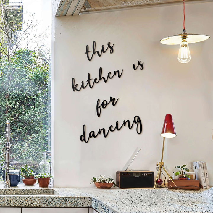 Matte black modern industrial metal wall art reading ‘This Kitchen Is For Dancing’ — five floating 2 mm thick steel pieces in playful script, easy no‑drill wall installation, customizable layout for kitchen décor