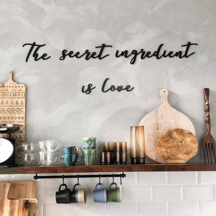 Matte black modern industrial metal wall art reading ‘The Secret Ingredient Is Love’—five 2 mm thick steel pieces, easy no‑drill adhesive installation, customizable layout for kitchen or outdoor décor