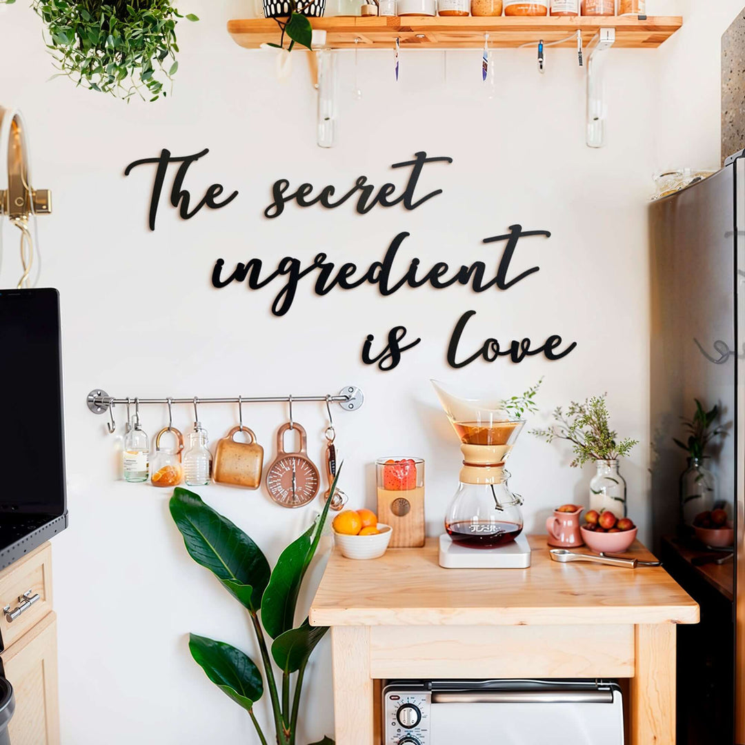 Matte black modern industrial metal wall art reading ‘The Secret Ingredient Is Love’—five 2 mm thick steel pieces, easy no‑drill adhesive installation, customizable layout for kitchen or outdoor décor